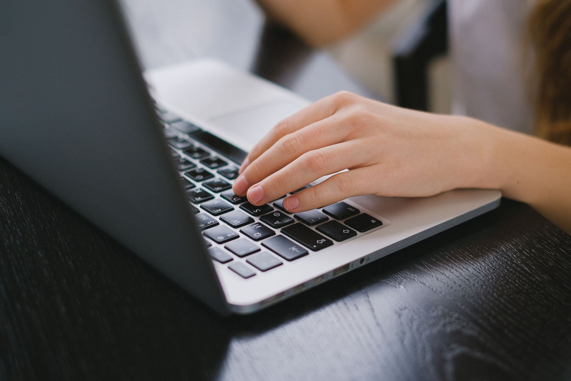 hand typing on a laptop computer